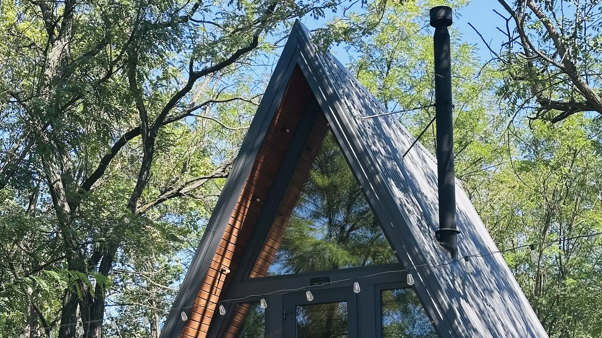 A-frame будиночок FILLAGE з дерев’яною терасою серед літніх дерев